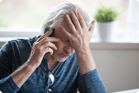 Image: man in discomfort making a phone call