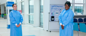 Katerina Pegg and Senior Infection Control Specialist Nurse Sophie Byfield wearing surgical gowns